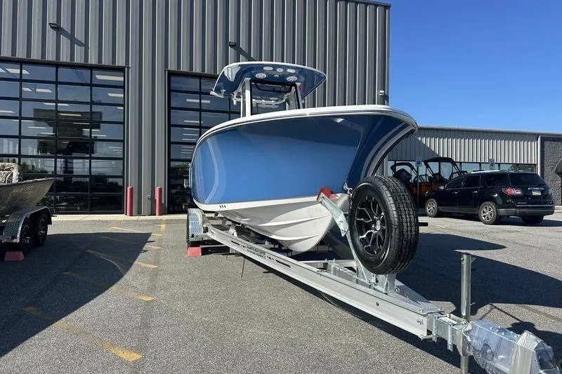 Slide: The Image of 2026 Sportsman Heritage 231 Center Console boat on trailer, parked outside a warehouse. - 6