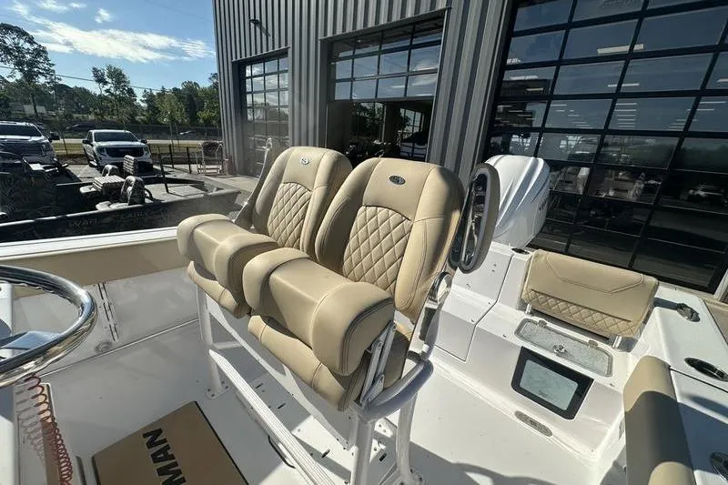 Slide: The Image of 2026 Sportsman Heritage 231 Center Console boat with beige seating in showroom. - 7