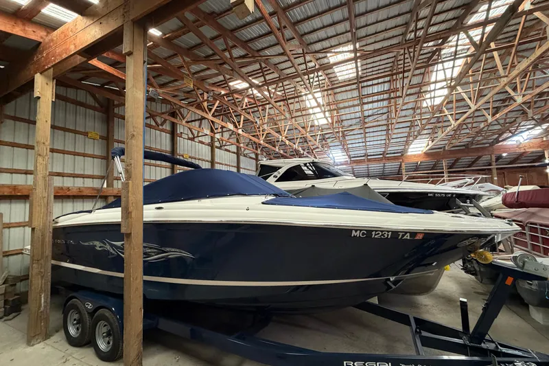 Slide: The Image of 2008 Regal 2700 Bowrider boat stored in a wooden indoor facility. - 11
