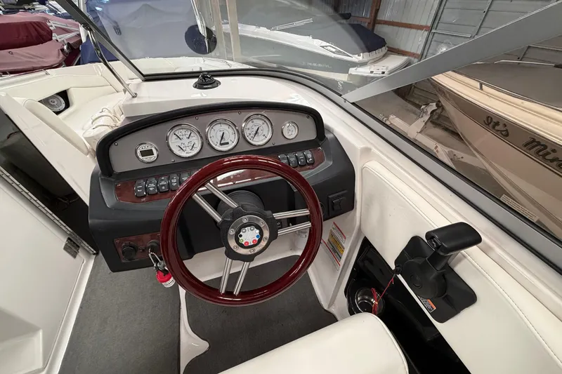 Slide: The Image of 2008 Regal 2700 Bowrider dashboard with gauges and steering wheel in a boat showroom. - 18