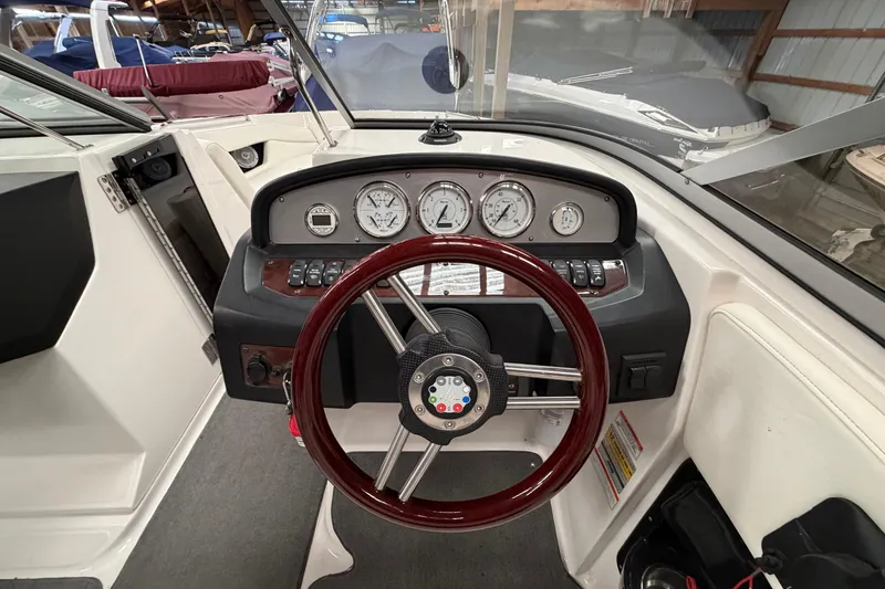 Slide: The Image of 2008 Regal 2700 Bowrider dashboard with gauges and steering wheel in a boat interior. - 20