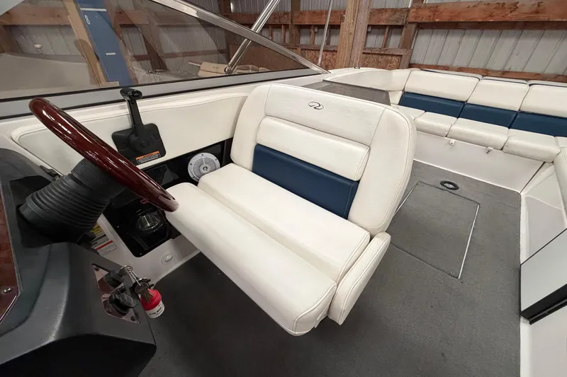 Slide: The Image of 2008 Regal 2700 Bowrider interior with white and blue seating, steering wheel, and dashboard. - 23