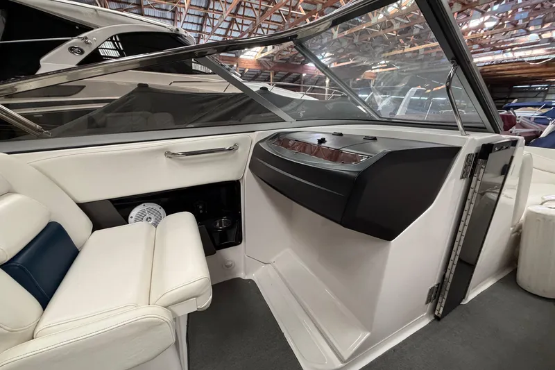 Slide: The Image of Interior of a 2008 Regal 2700 Bowrider boat with white seating and dashboard. - 25
