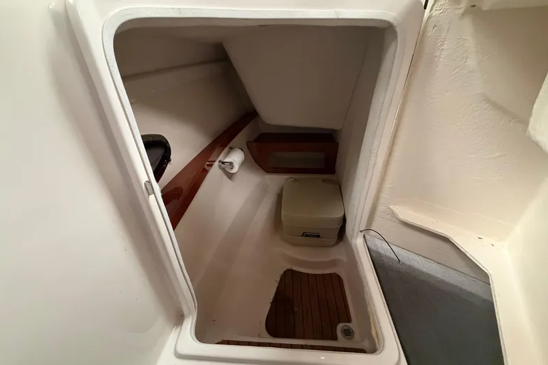 Slide: The Image of 2008 Regal 2700 Bowrider interior cabin with compact toilet and wooden flooring. - 26