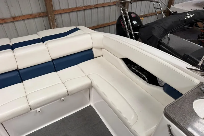 Slide: The Image of 2008 Regal 2700 Bowrider interior with white and blue seating in a boat garage. - 32