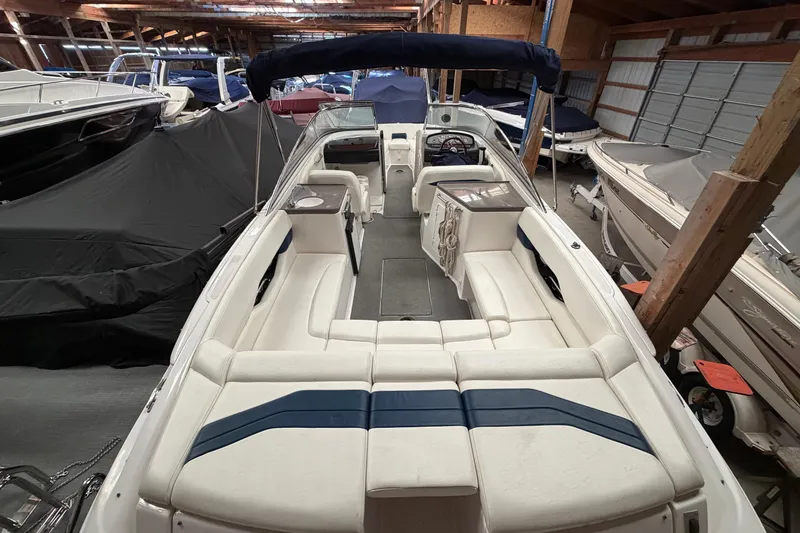 Slide: The Image of 2008 Regal 2700 Bowrider boat with spacious seating, stored indoors among other boats. - 33