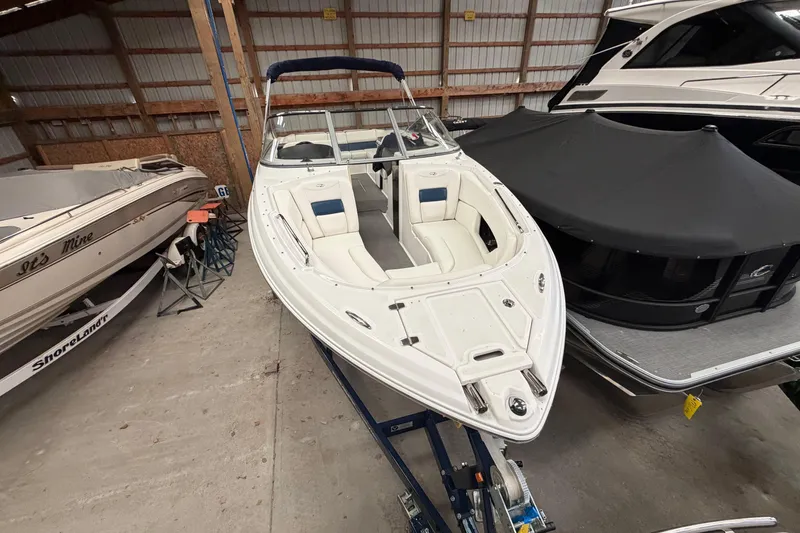 Slide: The Image of 2008 Regal 2700 Bowrider boat in storage, featuring white and blue seating. - 9