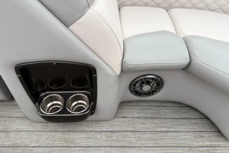 Slide: The Image of 2022 Manitou 230 Encore SL SHP boat interior with cup holders and speaker. - 10