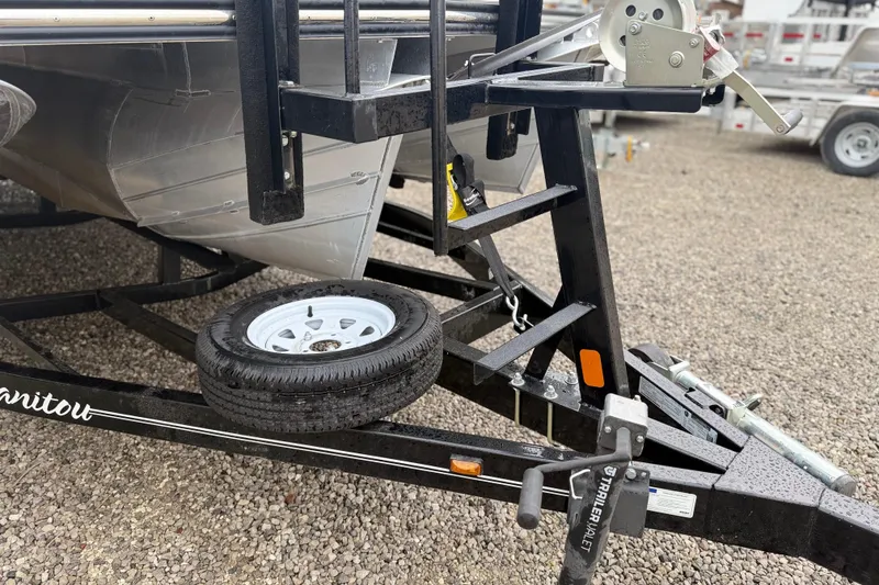 Slide: The Image of Trailer hitch and spare tire of 2022 Manitou 230 Encore SL SHP on gravel. - 11