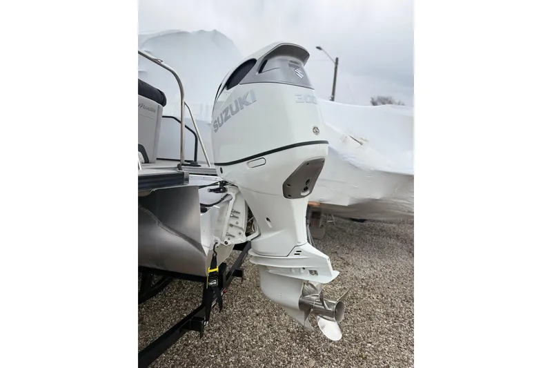 Slide: The Image of 2022 Manitou 230 Encore SL SHP with Suzuki outboard motor, parked on gravel. - 14