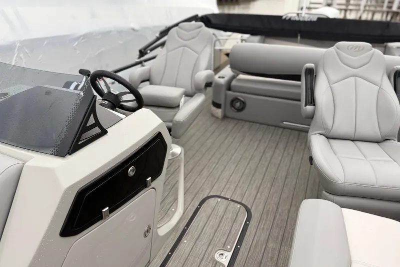 Slide: The Image of 2022 Manitou 230 Encore SL SHP boat interior with gray seating and steering console. - 6