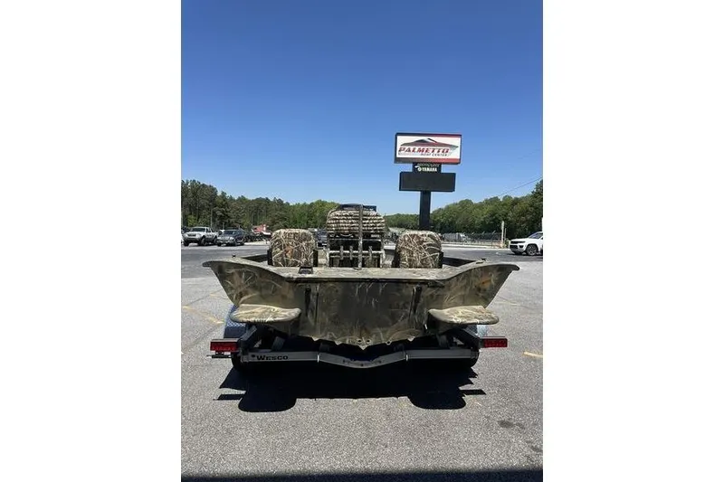 Slide: The Image of 2026 War Eagle 2170 Blackhawk boat on trailer, camo design, parked outdoors. - 10