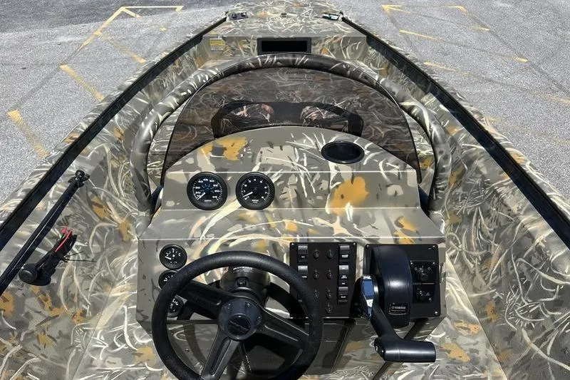 Slide: The Image of Camouflage interior of 2026 War Eagle 2170 Blackhawk boat with steering and control panel. - 11