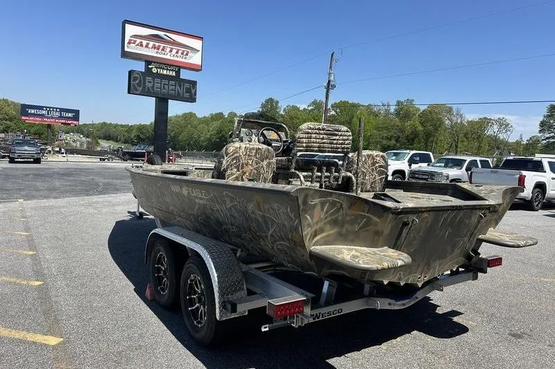 Slide: The Image of Camouflage War Eagle 2170 Blackhawk boat on trailer at dealership, 2026 model. - 8
