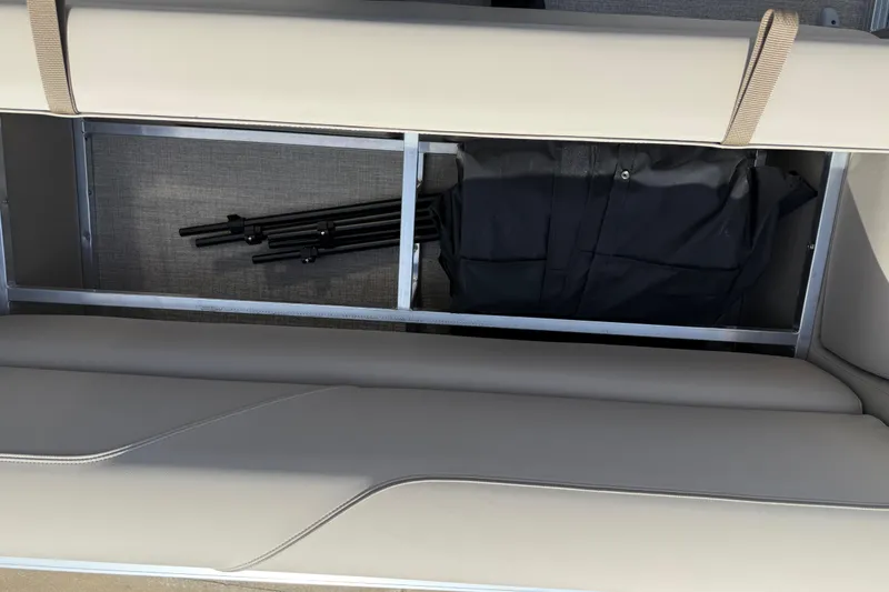 Slide: The Image of Under-seat storage in 2026 Avalon VENTURE QUAD LOUNGE, featuring folded equipment and black bag. - 93