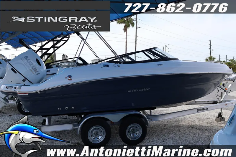 Slide: The Image of 2026 Stingray 211 DC boat on trailer, displayed at Antonietti Marine dealership. - 7