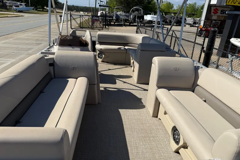 Slide: The Image of 2022 Tahoe Pontoon Sport Cruise with beige seating, parked outdoors. - 13