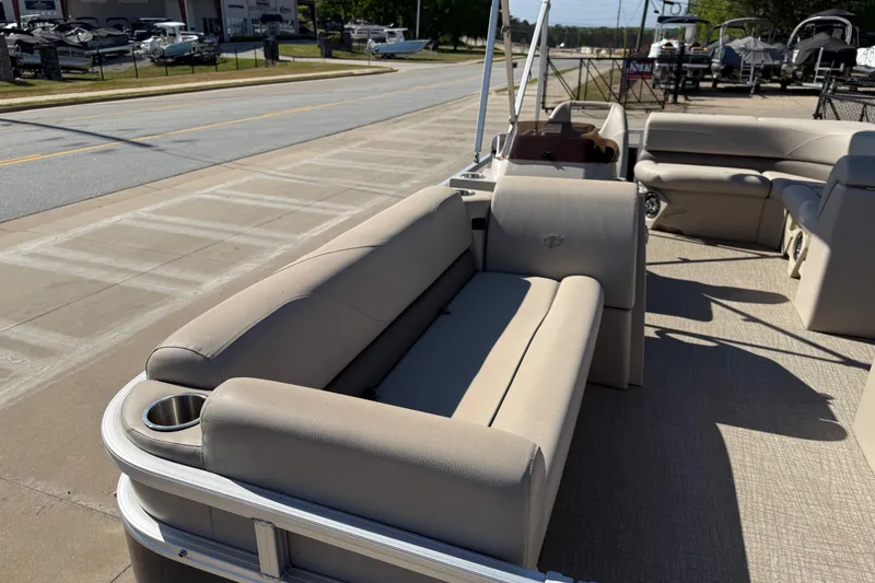 Slide: The Image of 2022 Tahoe Pontoon Sport Cruise with beige seating, parked on a sunny street. - 15