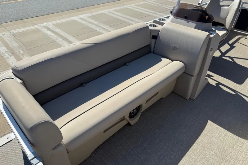 Slide: The Image of 2022 Tahoe Pontoon Sport Cruise interior with beige seating and cup holders. - 16