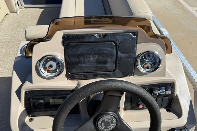 Slide: The Image of 2022 Tahoe Pontoon Sport Cruise dashboard with steering wheel and gauges. - 22
