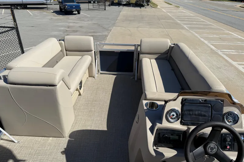 Slide: The Image of 2022 Tahoe Pontoon Sport Cruise interior with beige seating and steering console. - 25