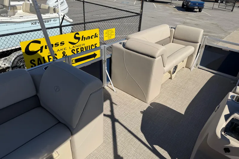 Slide: The Image of 2022 Tahoe Pontoon Sport Cruise interior with beige seating, displayed at a sales and service location. - 26