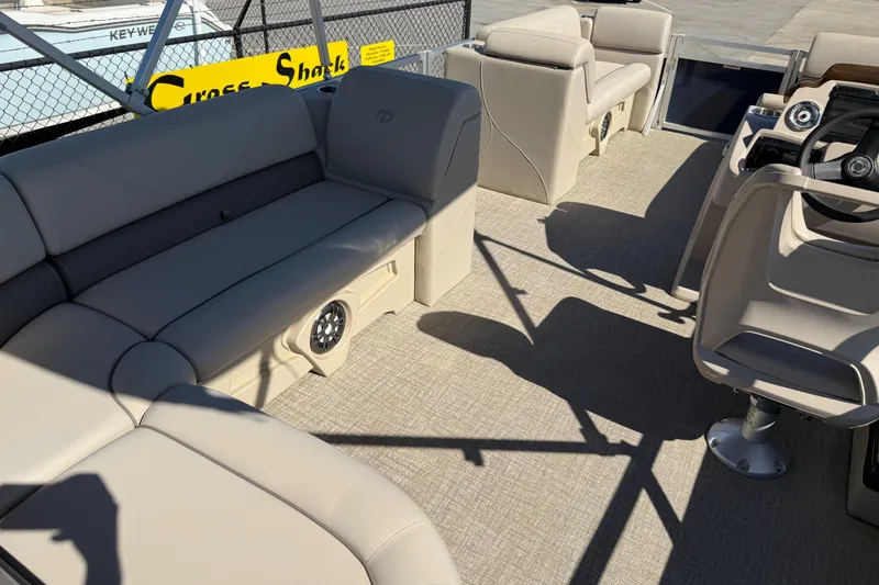 Slide: The Image of 2022 Tahoe Pontoon Sport Cruise interior with beige seating and steering console. - 33