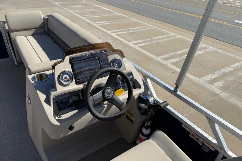 Slide: The Image of 2022 Tahoe Pontoon Sport Cruise boat interior with steering wheel and seating. - 36