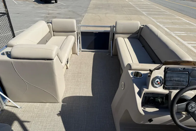Slide: The Image of 2022 Tahoe Pontoon Sport Cruise interior with beige seating and steering console. - 37