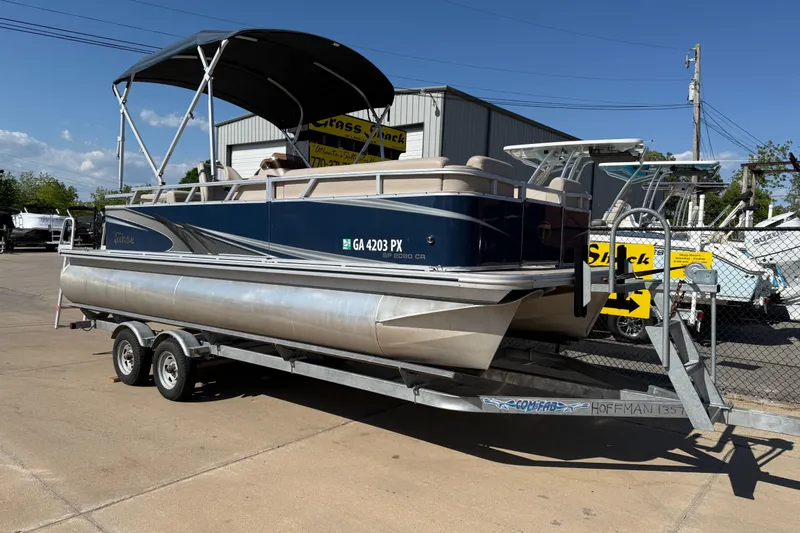 The Image of 2022 Tahoe Pontoon Sport Cruise on trailer, parked outdoors under clear blue sky. - 6
