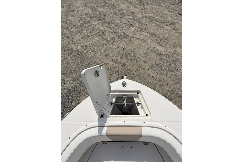 Slide: The Image of 2019 Robalo R207 Dual Console boat anchor compartment open on deck. - 10