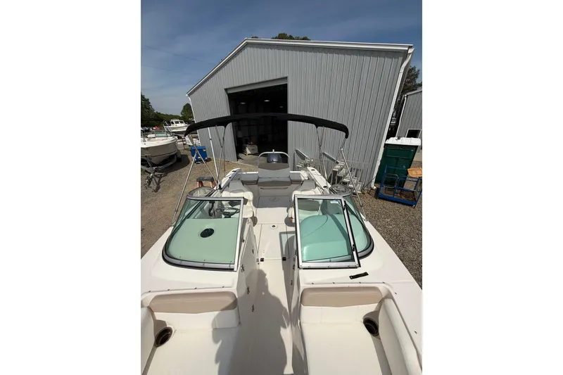 Slide: The Image of 2019 Robalo R207 Dual Console boat with open deck, parked near a metal building. - 11