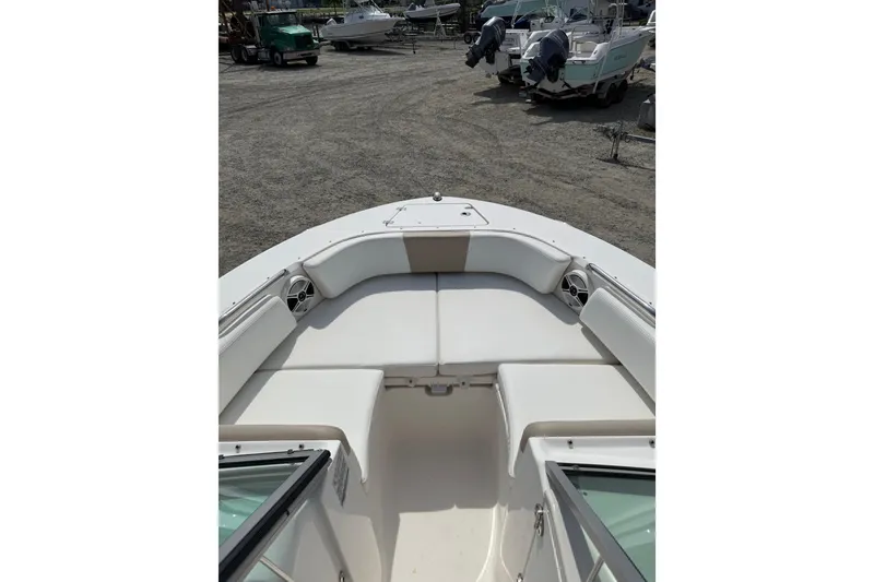 Slide: The Image of 2019 Robalo R207 Dual Console boat interior with white seating, parked outdoors. - 14