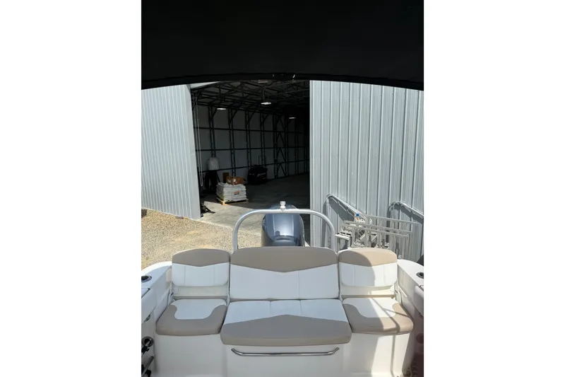 Slide: The Image of 2019 Robalo R207 Dual Console boat with beige seating, parked near a metal storage building. - 20