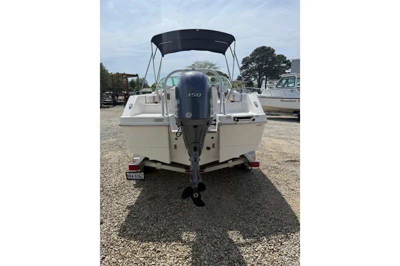 Slide: The Image of 2019 Robalo R207 Dual Console boat with outboard motor, parked on gravel. - 22