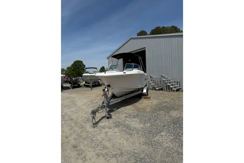 Slide: The Image of 2019 Robalo R207 Dual Console boat on trailer outside metal building. - 25