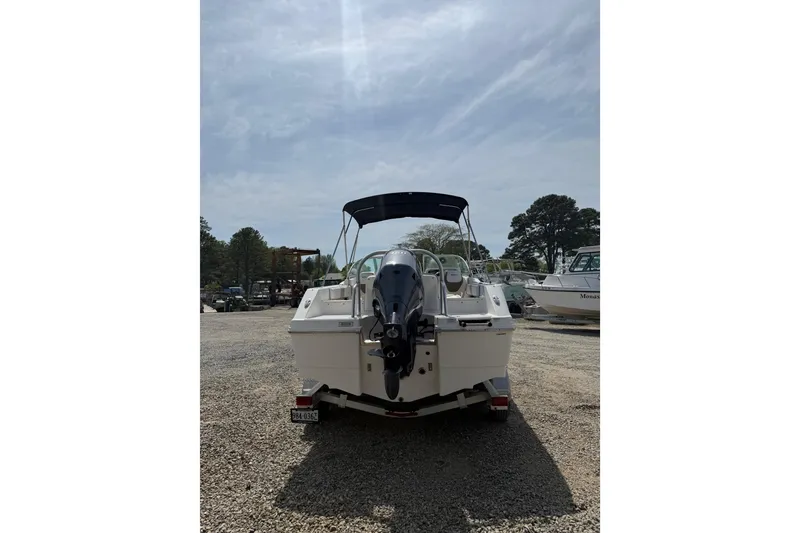Slide: The Image of 2019 Robalo R207 Dual Console boat with outboard motor, parked on gravel lot. - 27