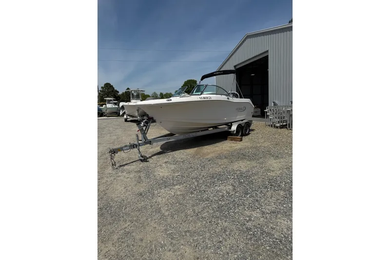 Slide: The Image of 2019 Robalo R207 Dual Console boat on trailer outside metal building. - 29