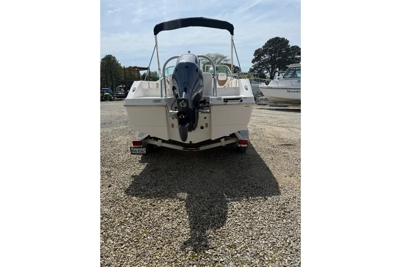Slide: The Image of 2019 Robalo R207 Dual Console boat with outboard motor, parked on gravel. - 31