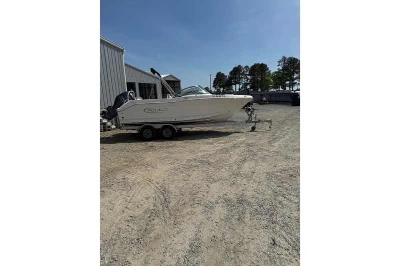 Slide: The Image of 2019 Robalo R207 Dual Console boat on trailer, parked outdoors near a building. - 33