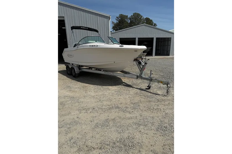 Slide: The Image of 2019 Robalo R207 Dual Console boat on trailer outside metal building. - 34