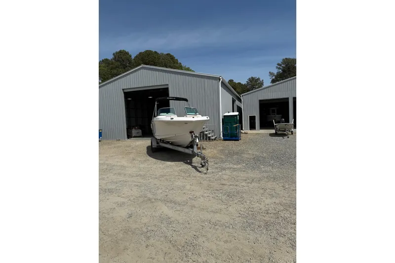 Slide: The Image of 2019 Robalo R207 Dual Console boat on trailer outside metal storage building. - 35
