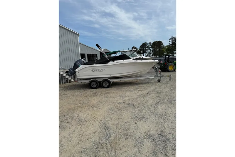 Slide: The Image of 2019 Robalo R207 Dual Console boat on trailer, parked outdoors. - 4