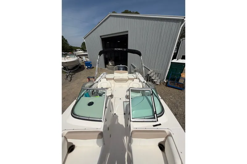 Slide: The Image of 2019 Robalo R207 Dual Console boat in front of a storage shed. - 8