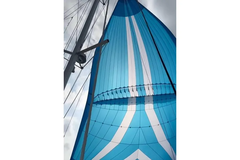 Slide: The Image of Blue and white sail on a 2016 Lagoon 450 F catamaran against a cloudy sky. - 11