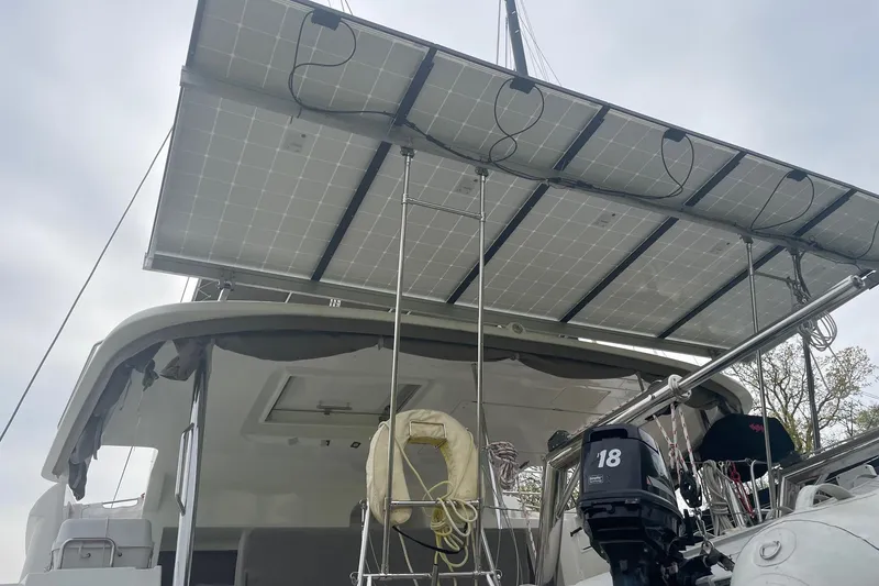 Slide: The Image of 2016 Lagoon 450 F catamaran with solar panels and outboard motor. - 12