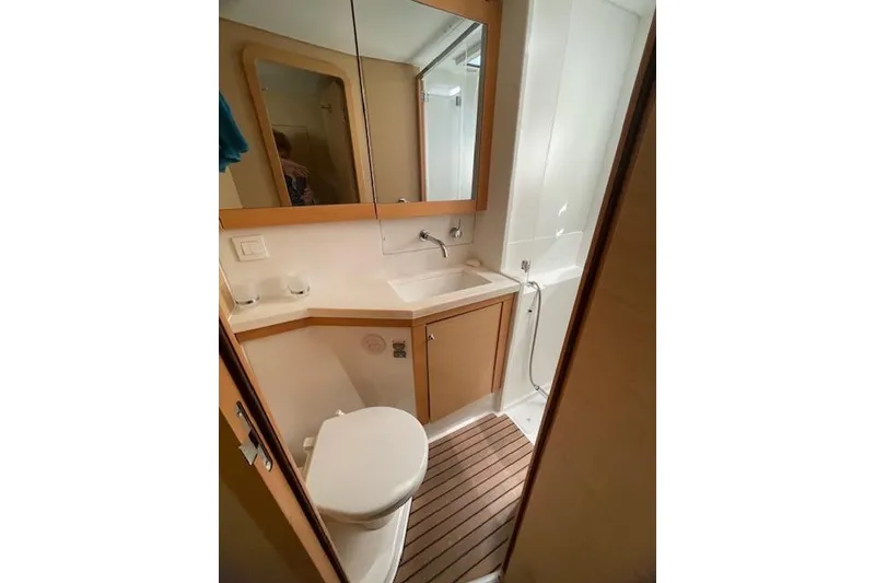 Slide: The Image of Bathroom interior of 2016 Lagoon 450 F yacht, featuring sink, toilet, and wooden flooring. - 16