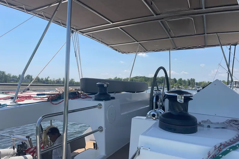 Slide: The Image of 2016 Lagoon 450 F catamaran deck with helm, winches, and canopy on a sunny day. - 19