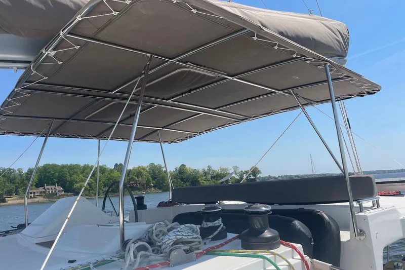 Slide: The Image of Lagoon 450 F 2016 catamaran with shaded deck, ropes, and scenic water view. - 20
