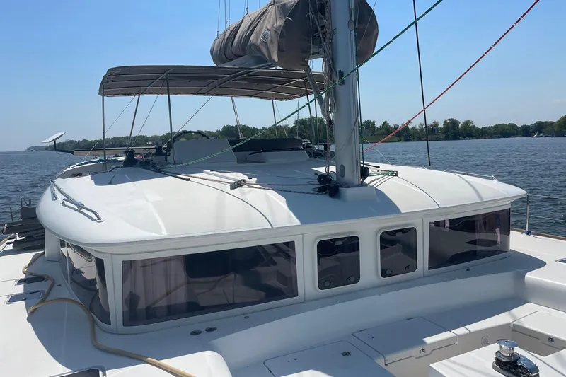 Slide: The Image of 2016 Lagoon 450 F catamaran on calm water, featuring sleek design and spacious deck. - 25